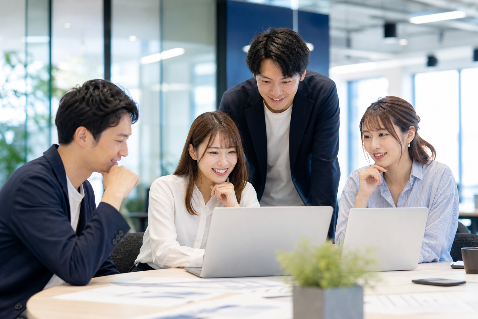日本人の若いチームがノートPCを囲んで業務課題を整理する風景